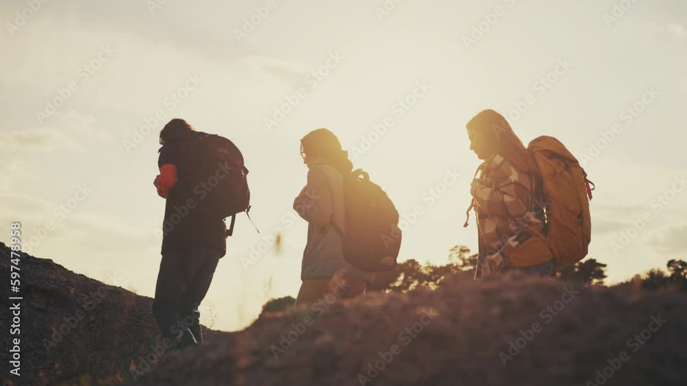 business. a group of climbers walk go through the mountains silhouette. business journey travel concept. hikers walk silhouette at sunset. climbers team with backpacks lifestyle