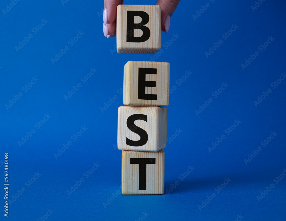 Best symbol. Concept word Best on wooden cubes. Businessman hand. Beautiful blue background. Business and Best concept. Copy space. Best symbol. Concept word Best on wooden cubes. Businessman hand. Beautiful blue background. Business and Best concept. Copy space.