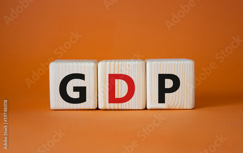 GDP - Gross domestic product symbol. Concept word GDP on wooden cubes. Beautiful orange background. Business and GDP concept. Copy space.