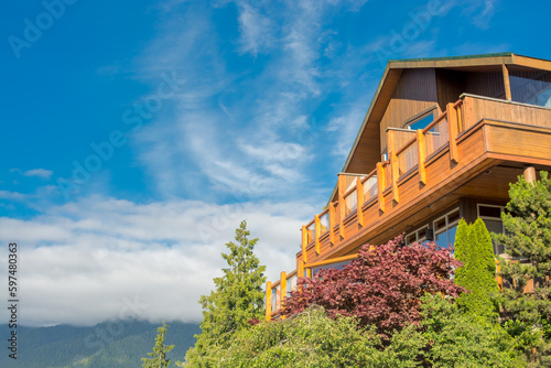 Top of wooden residential house on blue sky background photo