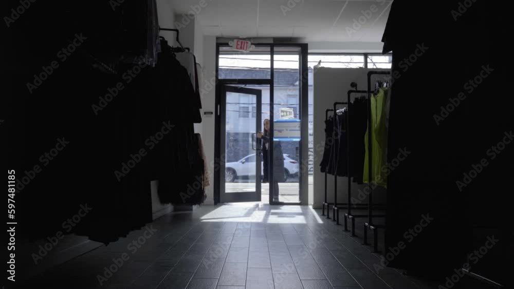 Woman enters retail store and turns on the light Woman enters retail store and turns on the light