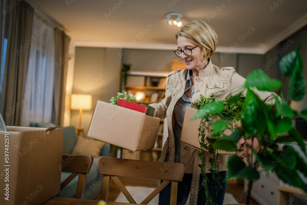 Senior woman caucasian female pack or unpack boxes with stuff moving