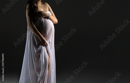 woman in a white dress on a grey background with copy space