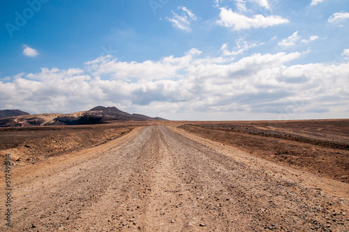 View of a road in a volcanic desert area in Fuerteventura, Canary Islands.