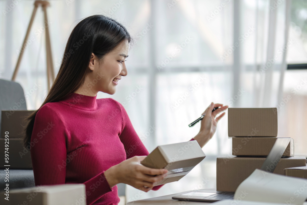 Startup small business entrepreneur SME, asian woman packing cloth in box. Portrait young Asian small business owner home office, online sell marketing delivery, SME e-commerce telemarketing concept. Startup small business entrepreneur SME, asian woman packing cloth in box. Portrait young Asian small business owner home office, online sell marketing delivery, SME e-commerce telemarketing concept.