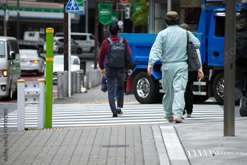 朝の交差点の横断歩道を渡る通勤する人々