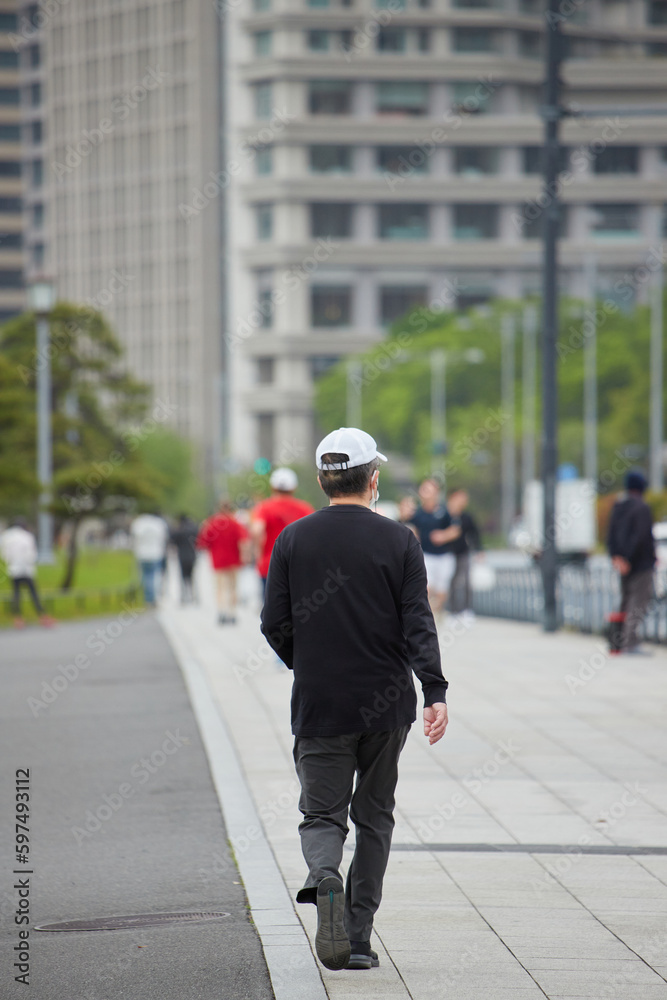 東京のオフィスビルと街並みでランニングしている人々の姿 東京のオフィスビルと街並みでランニングしている人々の姿
