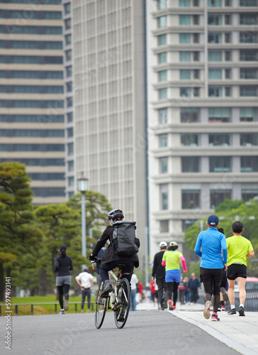 Wallpaper Mural 東京の皇居の前の道路で走るランナーたちの姿とオフィスビルの風景 Torontodigital.ca