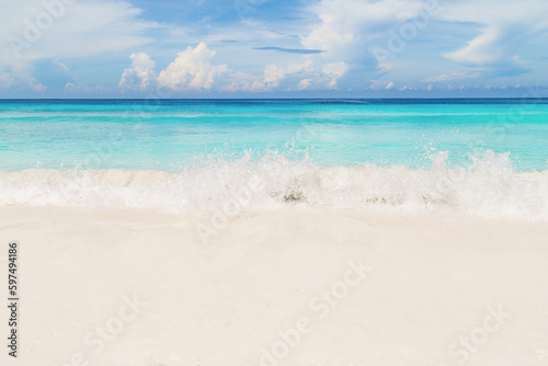 The Bright sand beach and blue wave white foam from the sea with blue sky on day in summer season