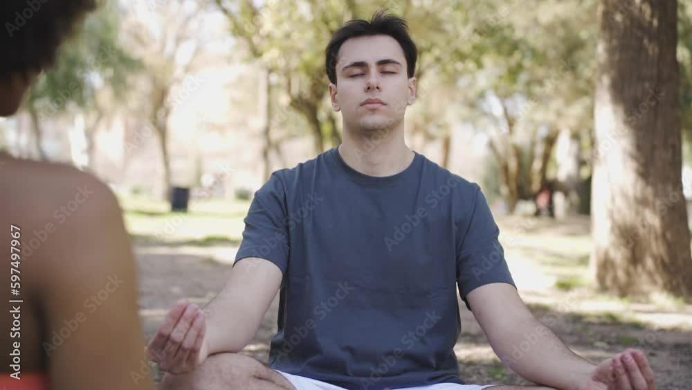 Calm man meditating in lotus pose in park Calm man meditating in lotus pose in park
