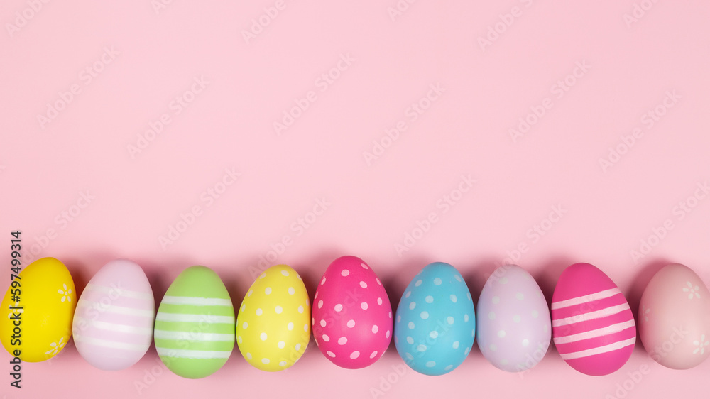 Happy easter banner. Colored Easter eggs on a pastel pink background. Copy space