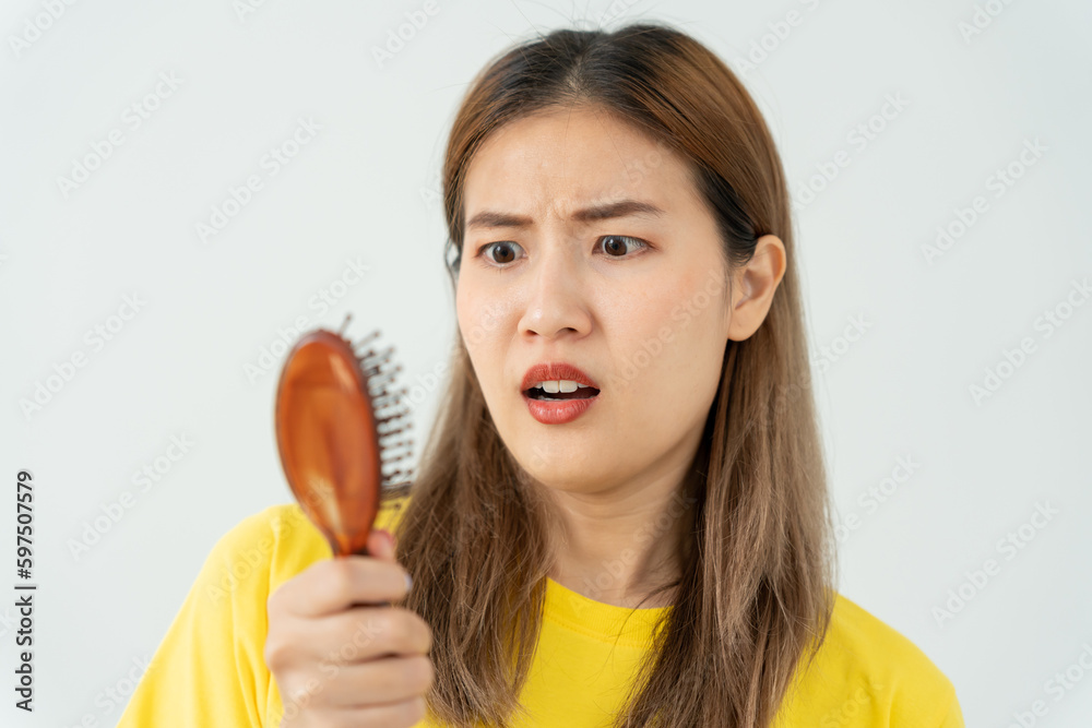 Asian woman very sad and upset looking at damaged hair, hair loss, hair thinning problem, vitamin deficiency, baldness, postpartum, biotin, zinc, menstrual or endocrine disorders, hormonal imbalance Asian woman very sad and upset looking at damaged hair, hair loss, hair thinning problem, vitamin deficiency, baldness, postpartum, biotin, zinc, menstrual or endocrine disorders, hormonal imbalance