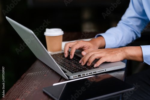 Businessman calculates financials with graph paper on the table on the cost of home office in the evening.