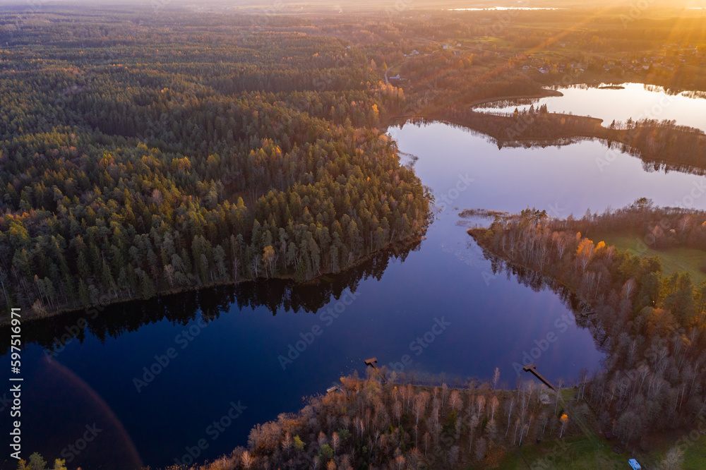 Drone aerial landscape photo - lakes with blue sky reflections and forest in Poland, sunset time, national park