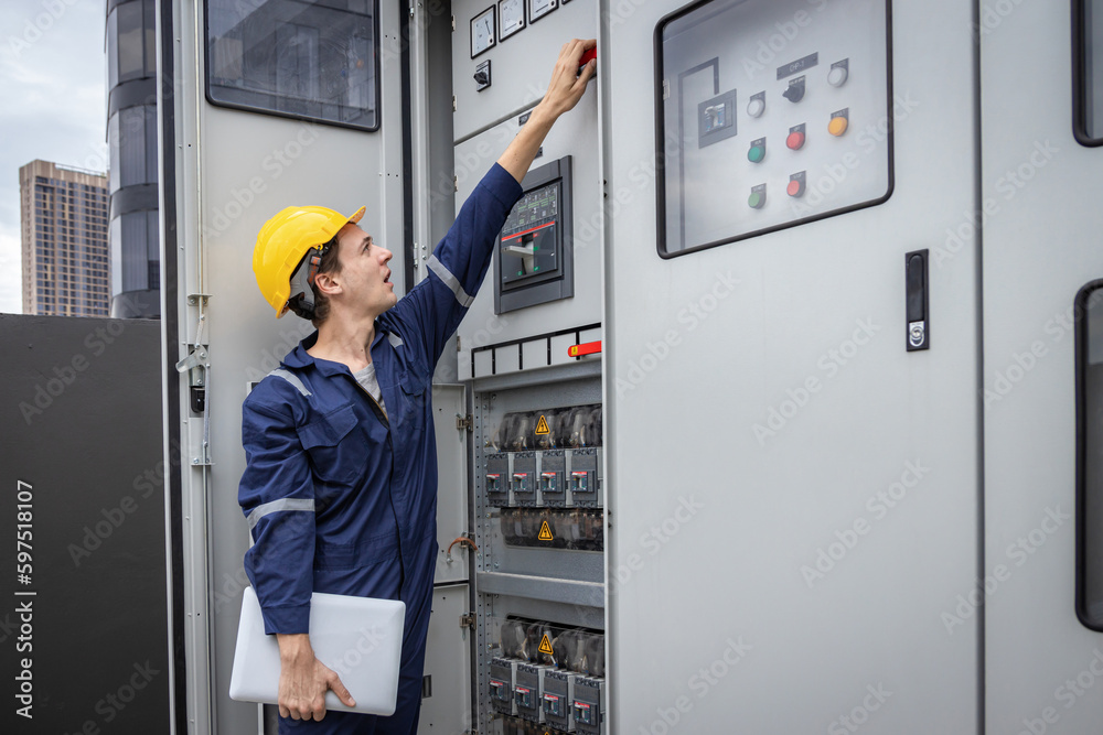Electrical engineer working in control room. Electrical engineer man checking Power Distribution Cabinet in the control room Electrical engineer working in control room. Electrical engineer man checking Power Distribution Cabinet in the control room