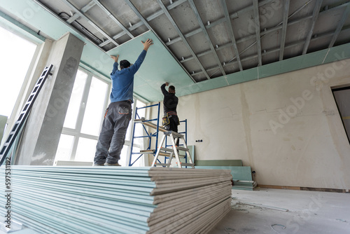 Construction worker installation ceiling work photo