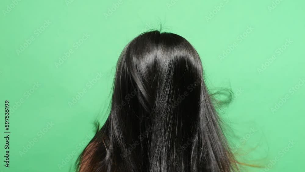 Close Up Back View Of A Woman Flipping Her Long And Black Straight Healthy Hair In The Green Screen Background Studio
