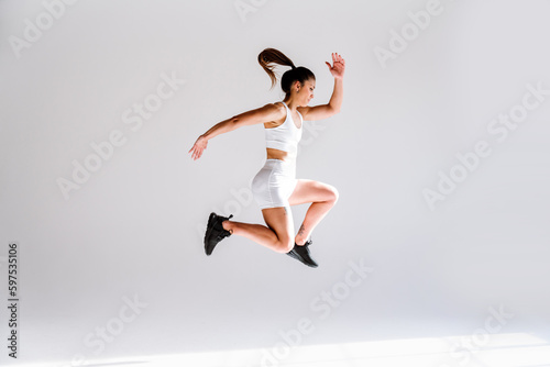 Fototapeta Naklejka Na Ścianę i Meble -  Young female athlete training in a gym using sport equipment. Fit woman working out . Concept about fitness, wellness and sport preparation.