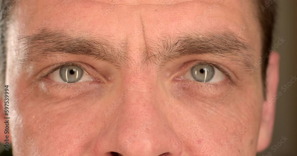 Close-up of male eye movement from bokeh to soft focus. Focusing attention on an object. Stripes of light on the surface of the eye. Close-up of male eye movement from bokeh to soft focus. Focusing attention on an object. Stripes of light on the surface of the eye.