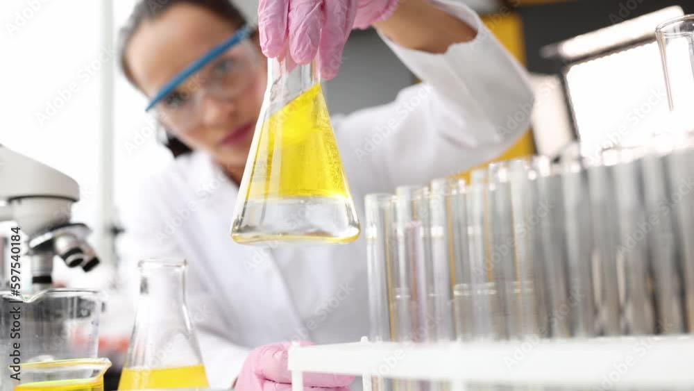Chemist technologist pouring motor oil into flask and onto car piston in laboratory 4k movie slow motion. Quality control of machine oils concept