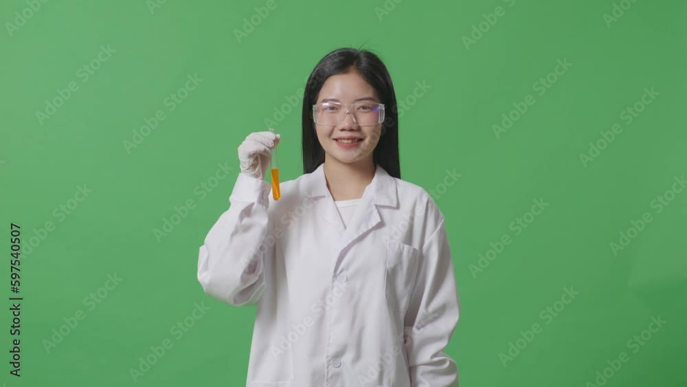 Asian Woman Scientist Smiling And Showing Orange Liquid In The Test Tube To Camera While Standing On The Green Screen Background In The Laboratory
Asian Woman Scientist Smiling And Showing Orange Liquid In The Test Tube To Camera While Standing On The Green Screen Background In The Laboratory