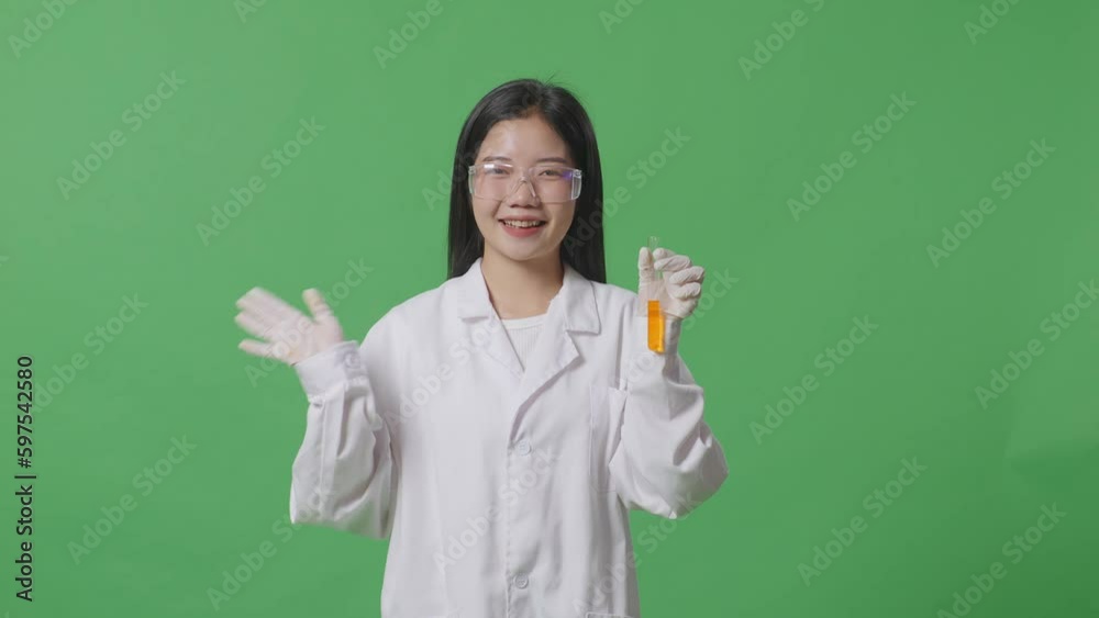 Asian Woman Scientist With Orange Liquid In The Test Tube Smiling And Waving Her Hand While Standing On The Green Screen Background In The Laboratory
Asian Woman Scientist With Orange Liquid In The Test Tube Smiling And Waving Her Hand While Standing On The Green Screen Background In The Laboratory