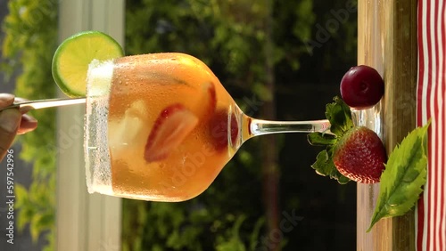 Preparation of a fruity cocktail with red fruits michelada in a vertical shot photo