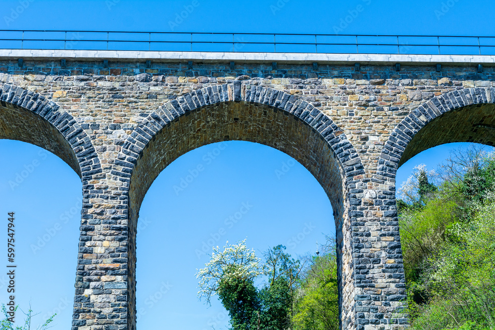 Historic stone railway viaduct on a sunny day against a blue sky