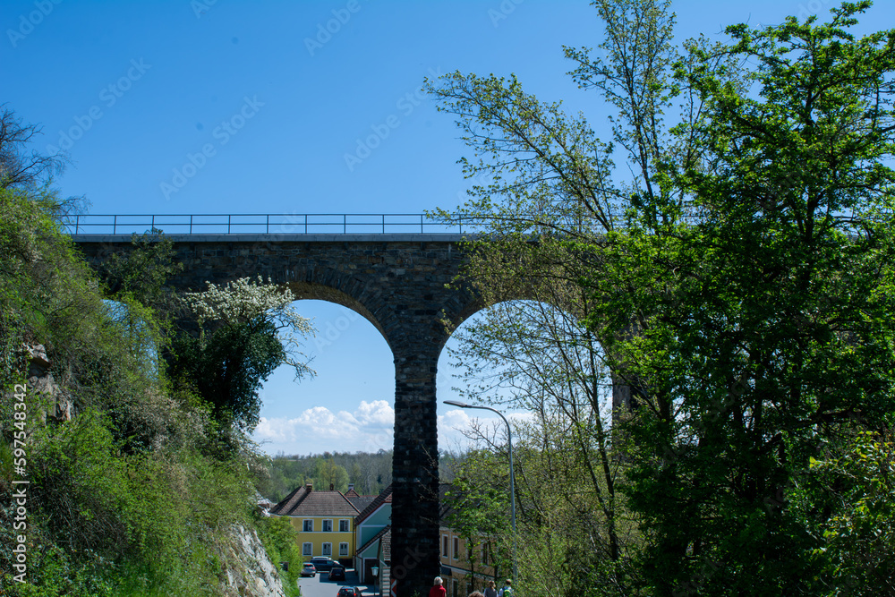 Historic stone railway viaduct on a sunny day against a blue sky