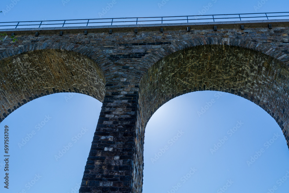 Historic stone railway viaduct on a sunny day against a blue sky