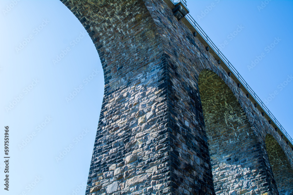 Historic stone railway viaduct on a sunny day against a blue sky