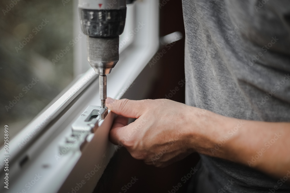 Caucasian man installs fittings for a window frame.