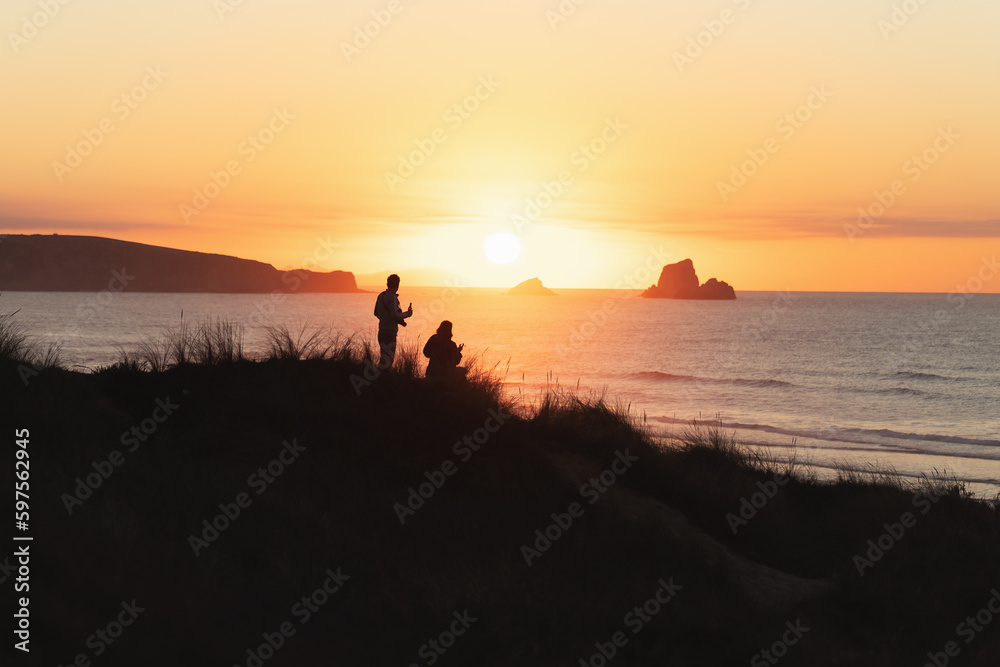 couple enjoying a sunset by the sea