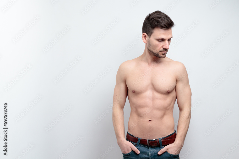 Portrait of handsome shirtless man  holding hands in pockets looking side. isolated grey background