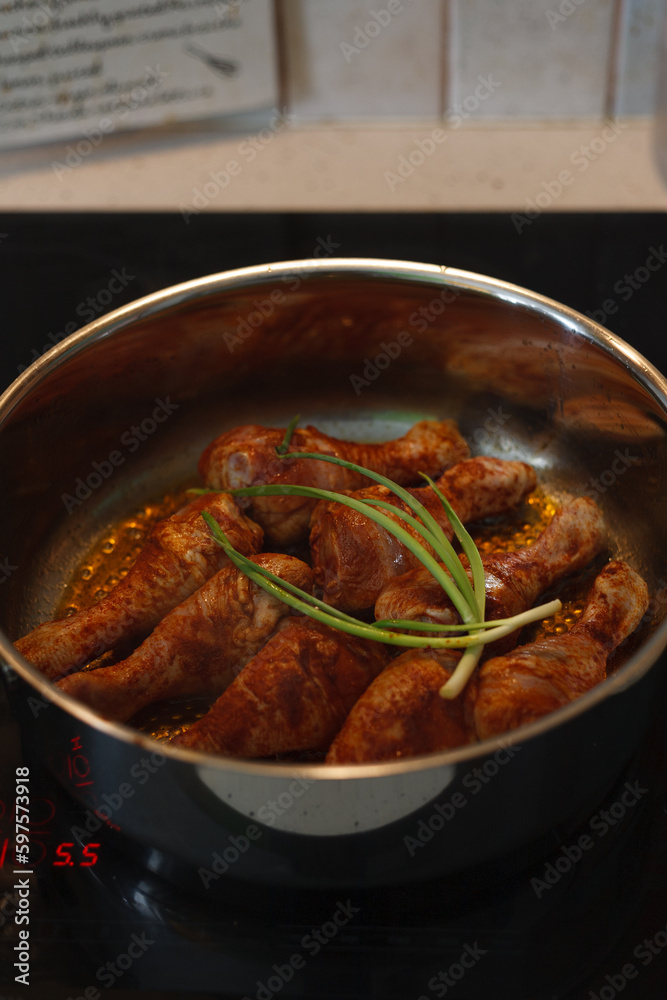 A large frying pan with fried chicken legs A large frying pan with fried chicken legs