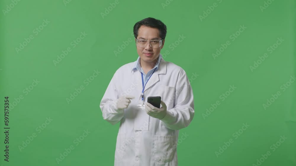 Asian Man Scientist Smiling And Pointing To Smartphone While Standing On The Green Screen Background In The Laboratory
Asian Man Scientist Smiling And Pointing To Smartphone While Standing On The Green Screen Background In The Laboratory