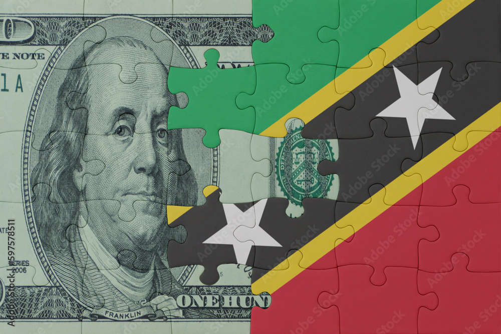 puzzle with the national flag of saint kitts and nevis and dollar money banknote. macro.concept. puzzle with the national flag of saint kitts and nevis and dollar money banknote. macro.concept.