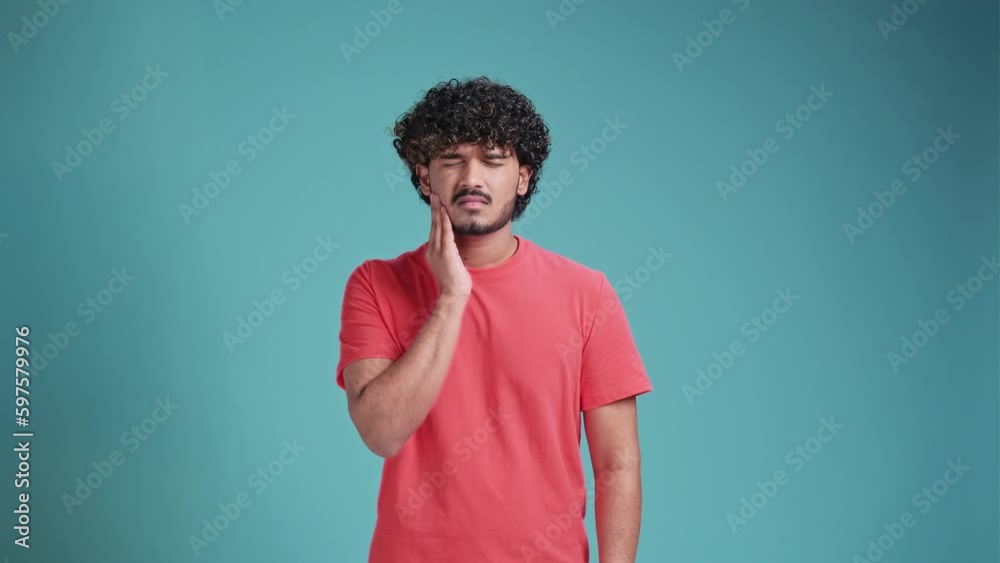 Dental problems. Portrait of unhealthy latin spanish man pressing sore cheek, suffering acute toothache, periodontal disease, cavities or jaw pain. on blue studio background Dental problems. Portrait of unhealthy latin spanish man pressing sore cheek, suffering acute toothache, periodontal disease, cavities or jaw pain. on blue studio background
