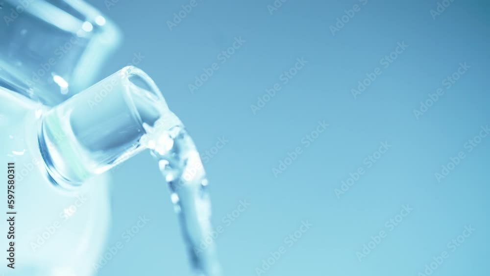Pouring water out of a clear glass teapot/pitcher on a white background. Pouring water out of a clear glass teapot/pitcher on a white background.