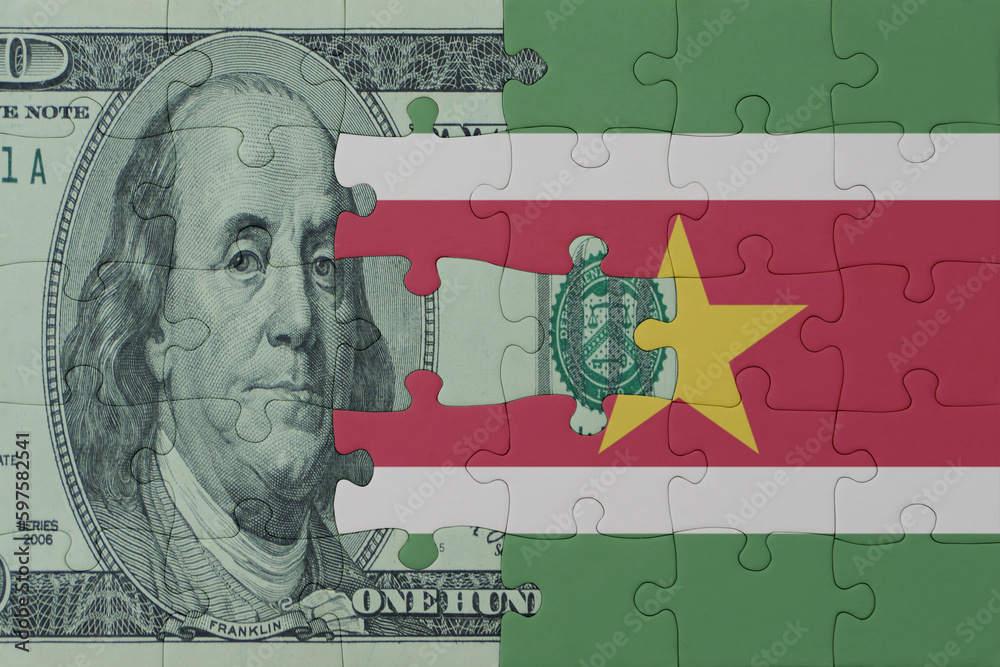 puzzle with the national flag of suriname and dollar money banknote. macro.concept.
