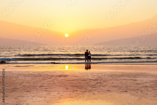 Couple (relationship) and orange sunset on Indian ocean