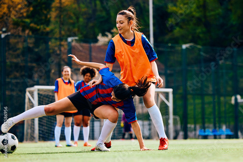 Soccer player trying to pass her rival during sports training at stadium. © Drazen