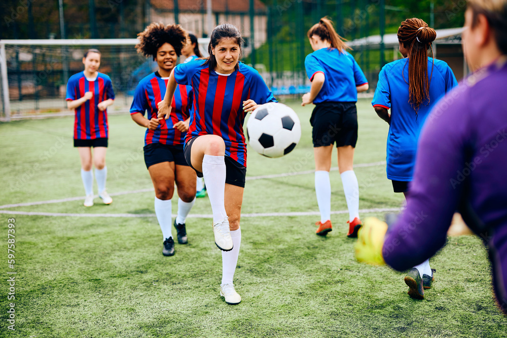 Women's soccer team having sports training on playing field.