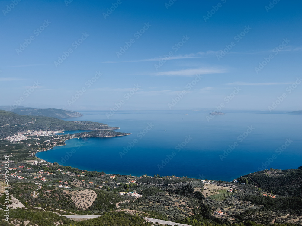 Blue sea at the foot of the mountain range merges with the horizon