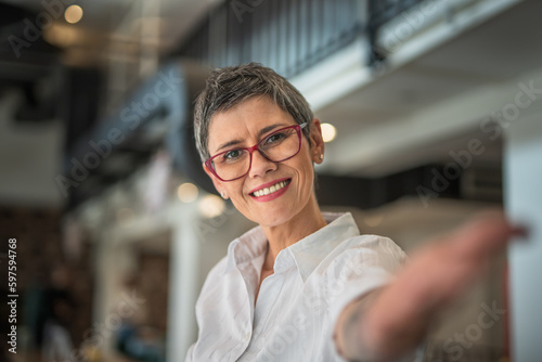One senior woman with grey hair and eye glasses making selfie and smiling, self portrait concept 