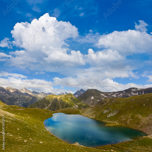 mountain valley with small lake  under blue cloudy sky © Yuriy Kulik