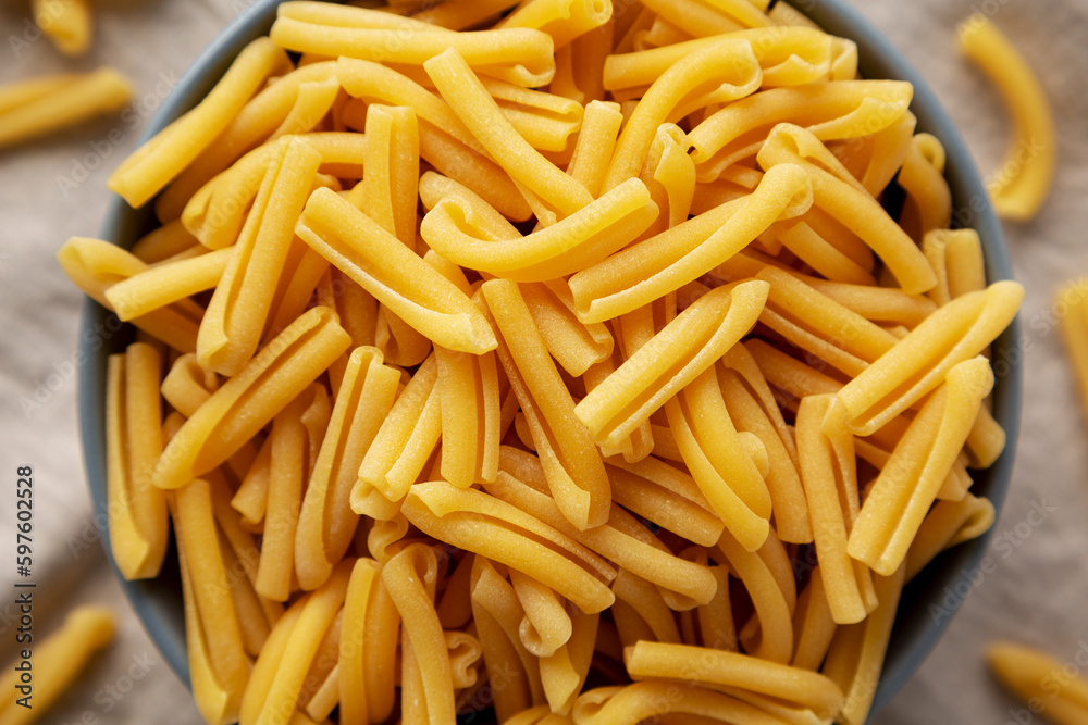 Homemade Raw Organic Caserecce Pasta in a Bowl on a white wooden background, top view. Flat lay, overhead, from above. Homemade Raw Organic Caserecce Pasta in a Bowl on a white wooden background, top view. Flat lay, overhead, from above.