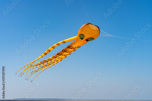 orange octopus kite flying on the blue sky in the kite festival photo