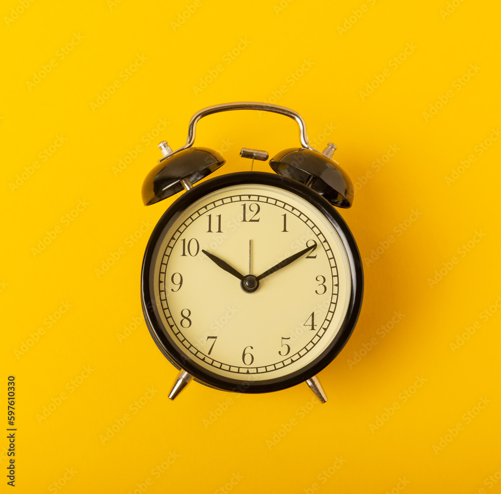 alarm clock on a bright yellow background.Top view.Close-up.Copy space. alarm clock on a bright yellow background.Top view.Close-up.Copy space.
