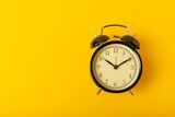 alarm clock on a bright yellow background.Top view.Close-up.Copy space.